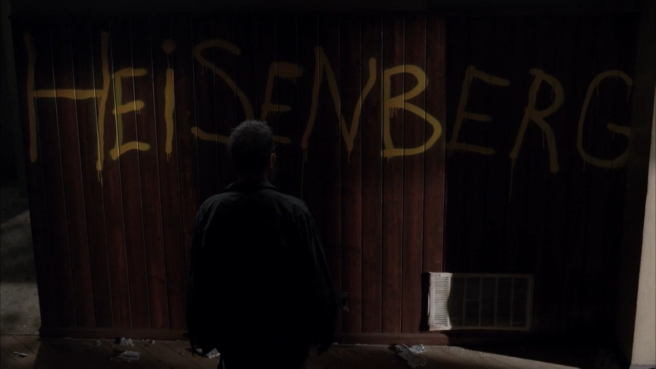 Walt looks at graffiti on the wall of his old house