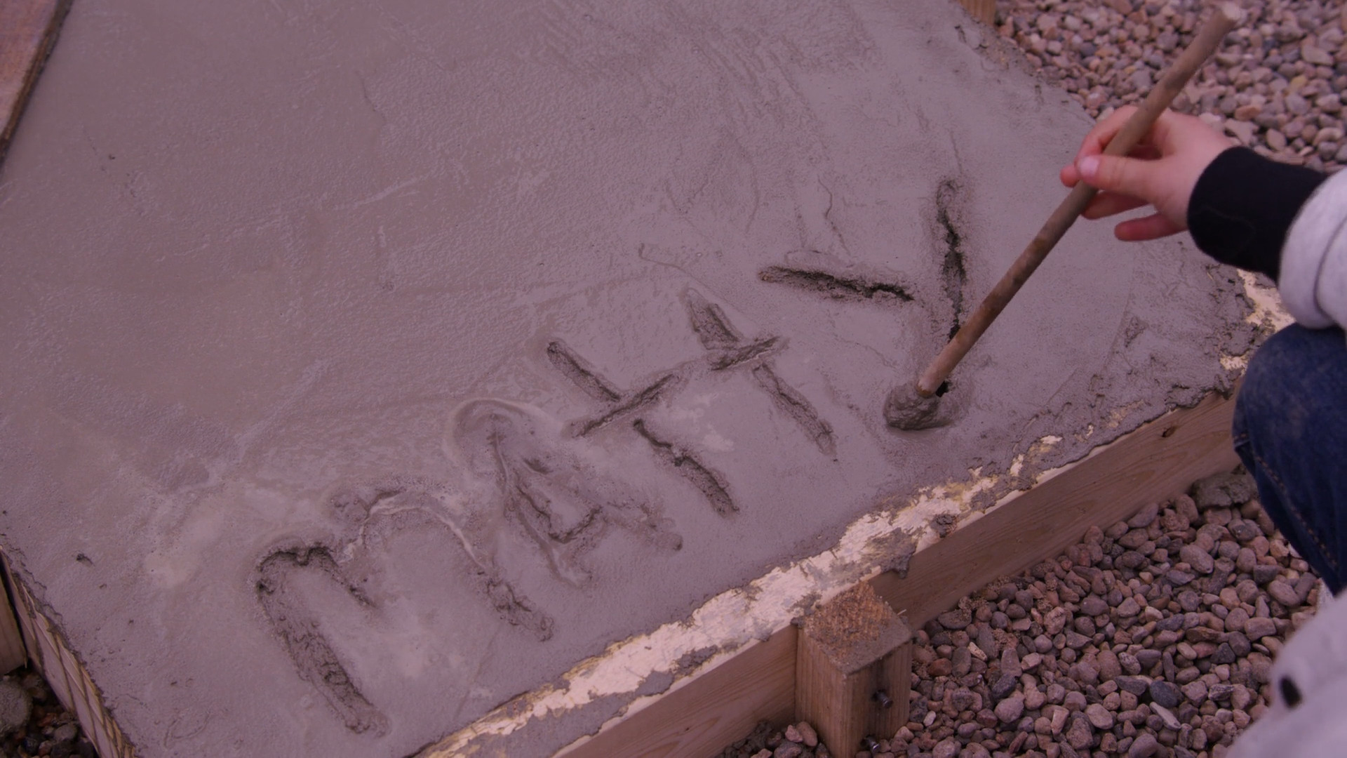 Mike's son writes his name in wet cement